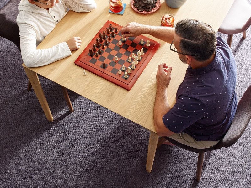 Father and son playing chess Carpet For Less in Belton, MO